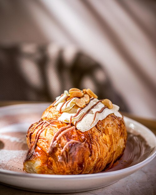 Zoom di croissant con cioccolato e arachidi in piatto bianco