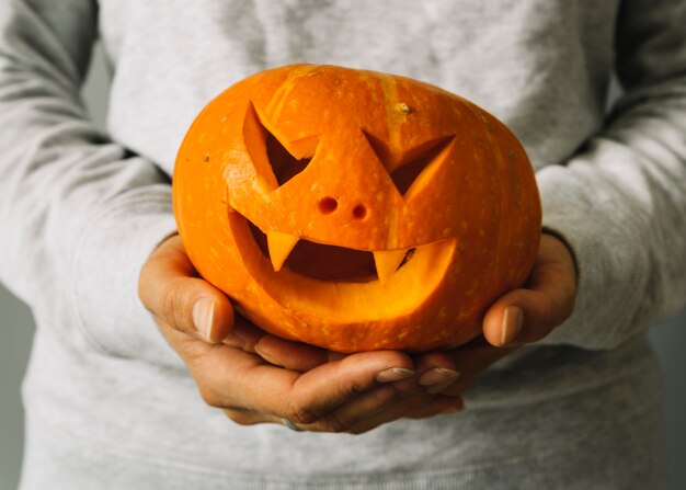 Zucca di Halloween intagliata tenuta della persona