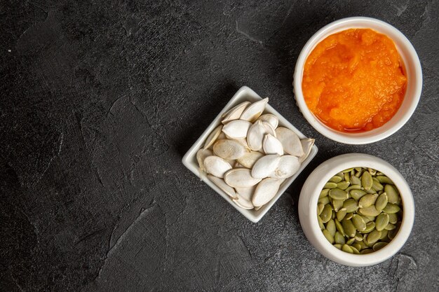 Zucca schiacciata vista dall'alto con semi su semi di colore di sfondo grigio scuro maturo