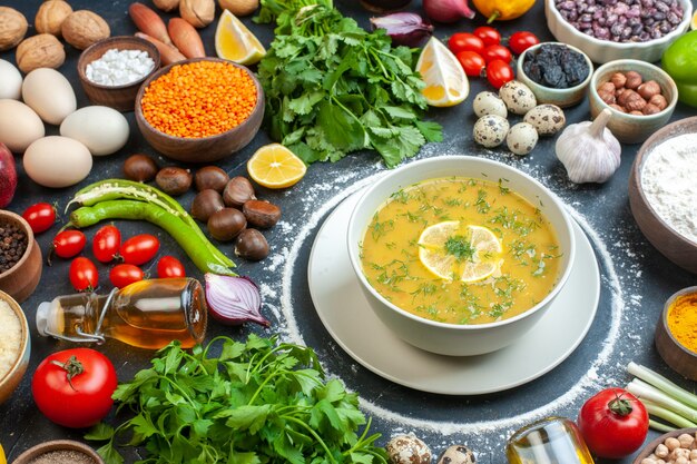 Zuppa appetitosa servita con limone e verde in una ciotola bianca e farina pomodoro olio bottiglia farina verde fasci uova