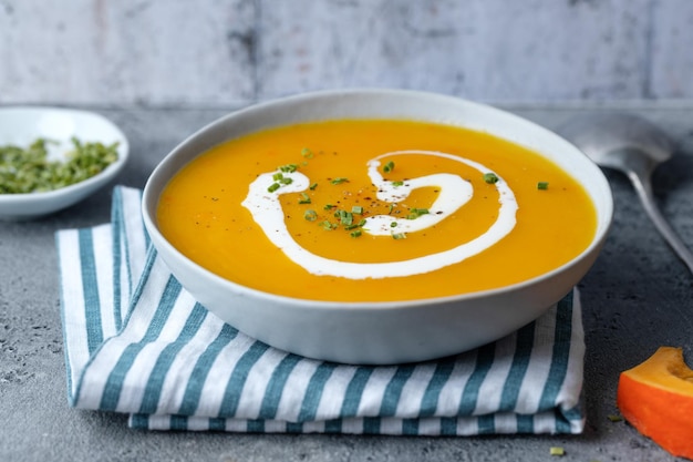 Zuppa autunnale in ciotola su sfondo grigio