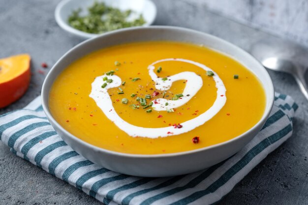 Zuppa autunnale in ciotola su sfondo grigio