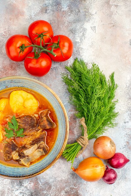 Zuppa di bozbash fatta in casa vista dall'alto un mucchio di cipolle pomodori aneto su superficie nuda