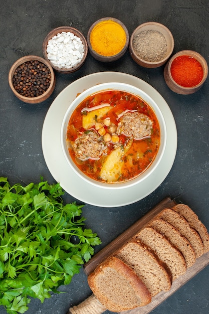 Zuppa di carne vista dall'alto con condimenti su sfondo grigio scuro