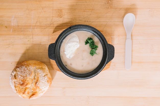 Zuppa di crema di funghi con pane e cucchiaio sul fondo di legno di struttura