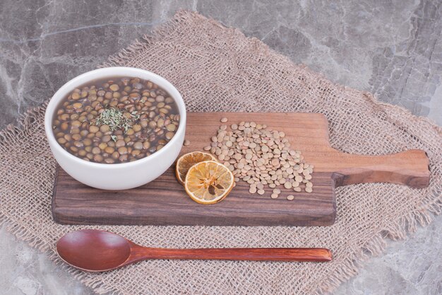 Zuppa di fagioli di lenticchie verdi in brodo in un piatto bianco.