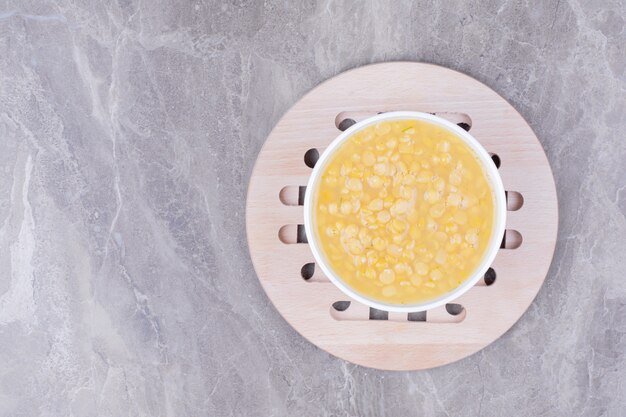 Zuppa di fagioli di piselli gialli in una tazza bianca sul marmo