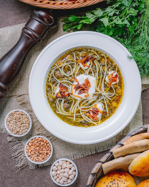 Zuppa di fagioli vista dall'alto con peperoni neri alla griglia panna acida tagliatelle di fagioli e verdure sul tavolo