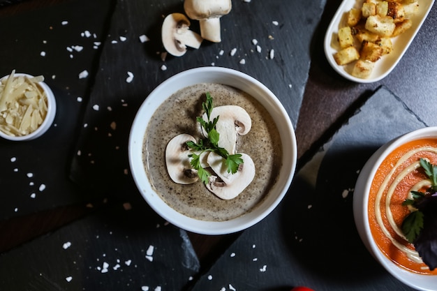 Zuppa di funghi decorata dalla vista superiore del sale del formaggio del prezzemolo