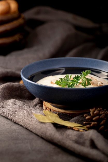 Zuppa di funghi in un barattolo blu su un panno grigio