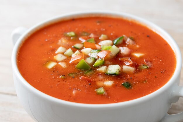 Zuppa di gazpacho spagnolo tradizionale in ciotola su tablexA di legno