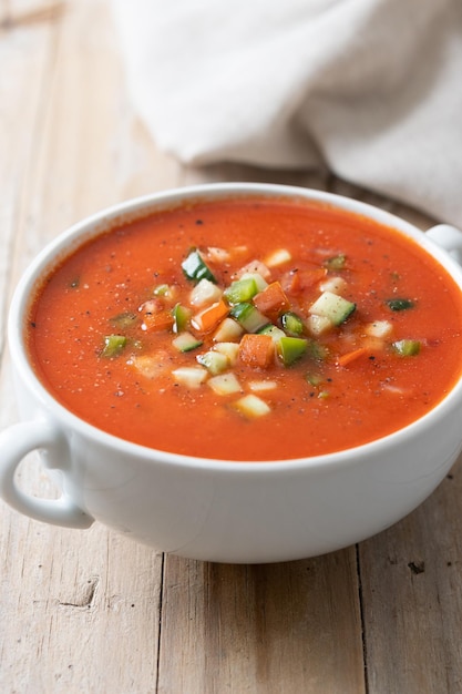 Zuppa di gazpacho spagnolo tradizionale in ciotola su tablexA di legno