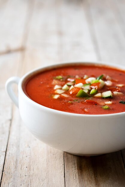 Zuppa di gazpacho spagnolo tradizionale in ciotola su tablexA di legno