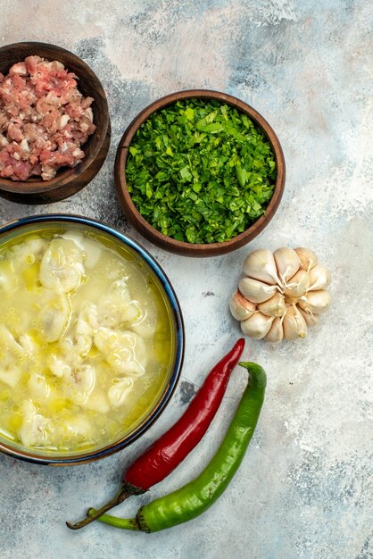 Zuppa di gnocchi di dushbara vista dall'alto in una ciotola ciotole di peperoni piccanti all'aglio con carne e verdure sulla superficie nuda