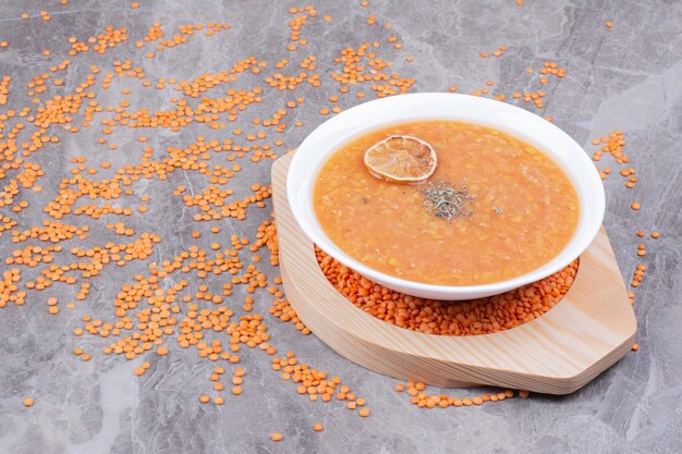 Zuppa di lenticchie rosse su un piatto di legno sul marmo