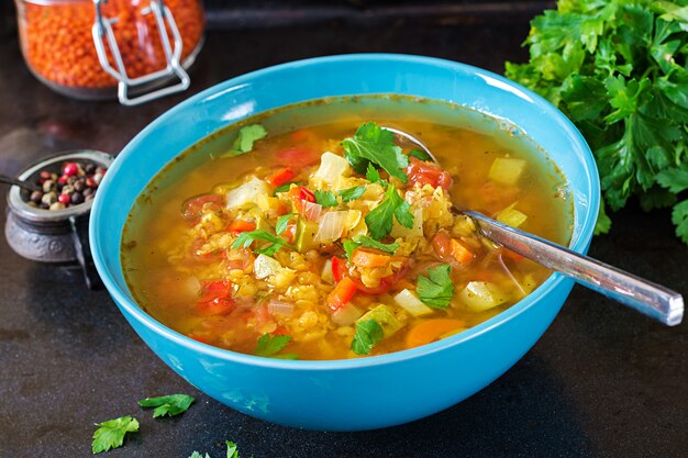 Zuppa di lenticchie rosse sulla superficie scura. Concetto di mangiare sano. Cibo vegano.