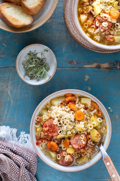 Zuppa di minestrone in padella su un tavolo luminoso vista dall'alto Zuppa italiana con pasta e verdure di stagione Delizioso concetto di cibo vegetariano