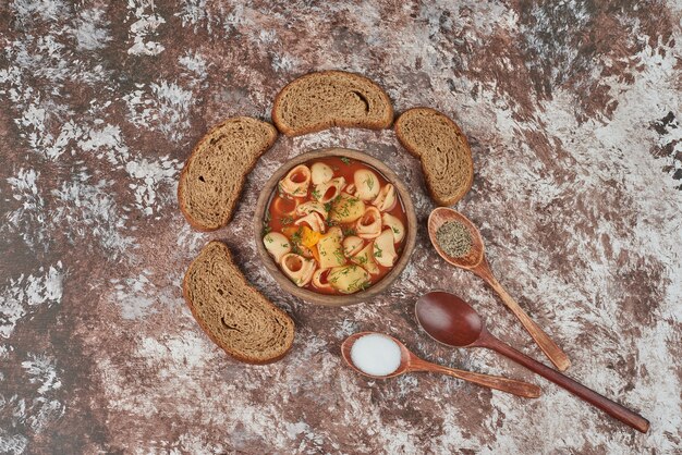 Zuppa di pasta con un piatto di verdure intorno