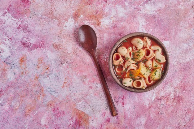 Zuppa di pasta in salsa di pomodoro in una tazza di legno.