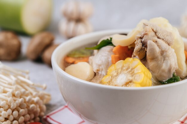 Zuppa di pollo con mais, funghi shiitake, funghi enoki e carote.