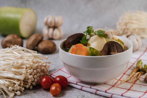 Zuppa di pollo con mais, funghi shiitake, funghi enoki e carote.