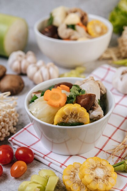 Zuppa di pollo con mais, funghi shiitake, funghi enoki e carote.