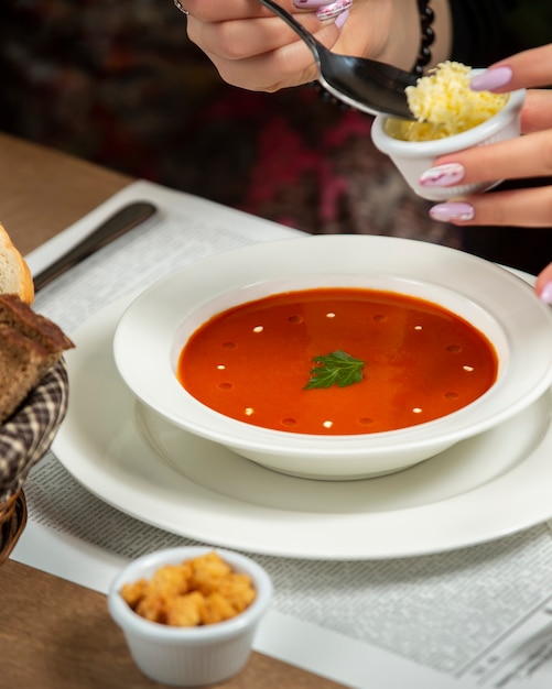 Zuppa di pomodoro con cracker e formaggio grattugiato