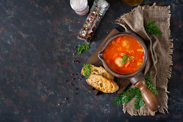 Zuppa di pomodoro piccante con polpette, pasta e verdure. Cena salutare. Vista dall'alto