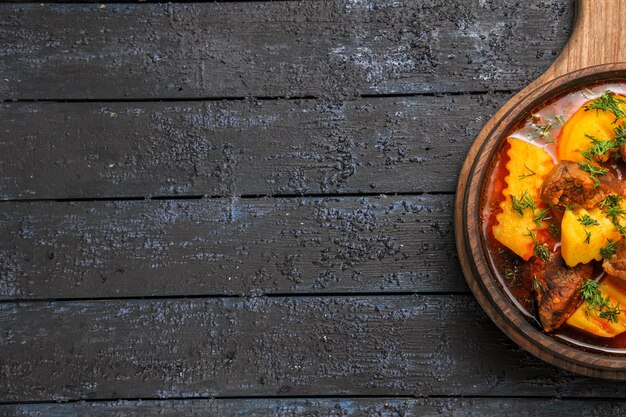 Zuppa di ragù di vista dall'alto con patate e verdure sulla scrivania scura