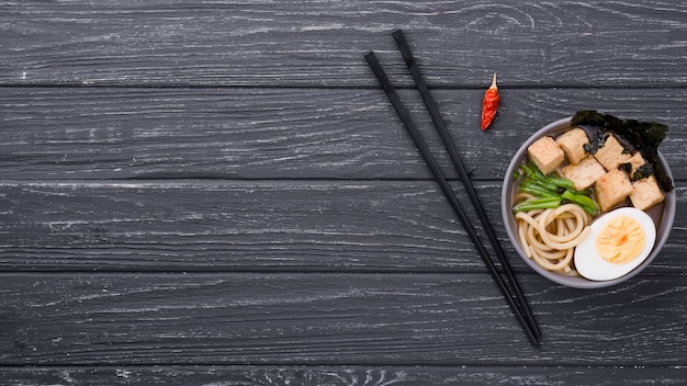 Zuppa di ramen sano vista dall'alto con uovo e bacchette