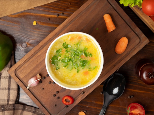 Zuppa di verdure brodo di pollo in tazza usa e getta servito con verdure verdi.