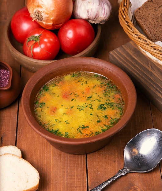 Zuppa di verdure di brodo di pollo con prezzemolo tritato in ciotola di ceramica.