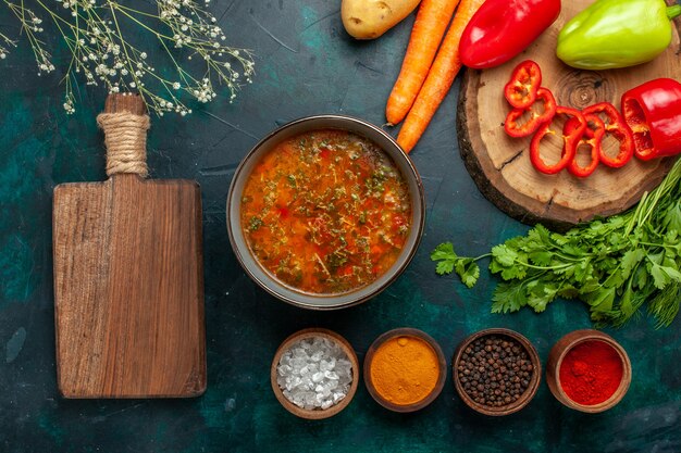 Zuppa di verdure vista dall'alto con verdure fresche e condimenti su zuppa di verdure cibo pasto ingrediente superficie verde scuro