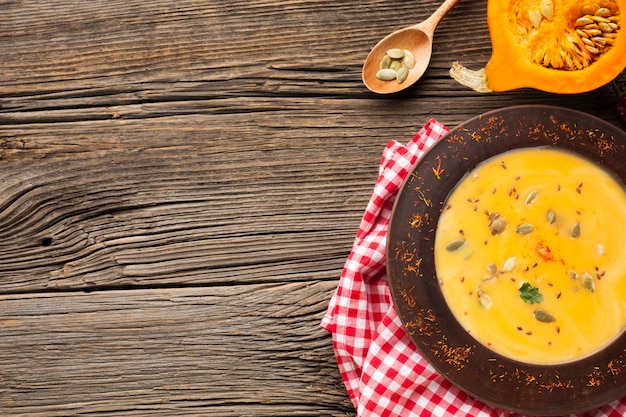 Zuppa di zucca piatta distesa e cucchiaio di legno con spazio di copia