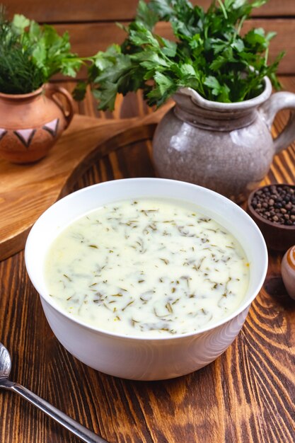 Zuppa tradizionale Dovga con verdure e vista laterale di yogurt bianco