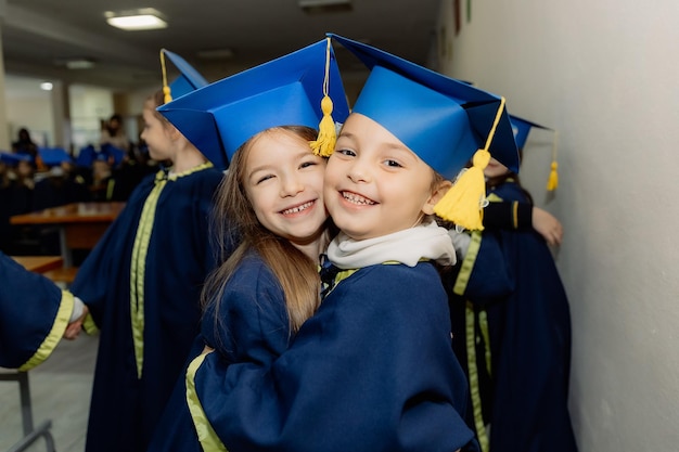 02024 Vinnitsa Ucraina Due felici scolari di prima elementare in un abbraccio di uniforme festivo sullo sfondo di altri studenti che sono stati appena iscritti alla prima elementare