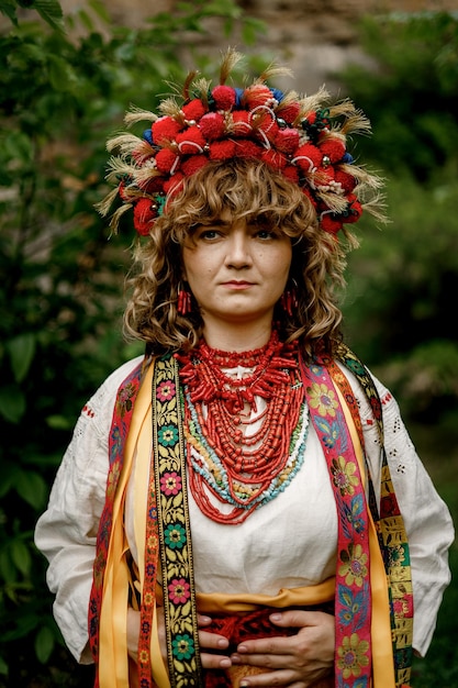 040622 Vinnitsa Ucraina ritratto di una bella donna che indossa un abito nazionale etnico ucraino intrecciato con ricami e sfondo naturale dei giardini ucraini