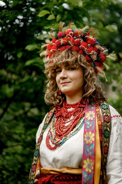 040622 Vinnitsa Ucraina ritratto di una bella donna che indossa un abito nazionale etnico ucraino tessuto con ricamo e sfondo naturale di giardini ucraini