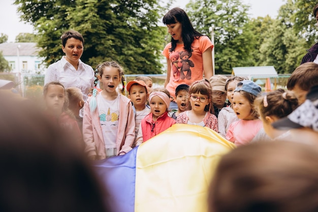 070722 Irpin Ucraina ritratti di bambini con in mano una grande bandiera ucraina e canti canti patriottici