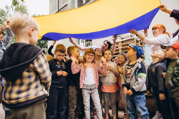 070722 Irpin Ucraina ritratti di bambini con in mano una grande bandiera ucraina e canti canti patriottici