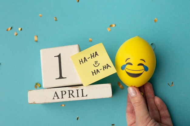 1 aprile Immagine del 1 aprile calendario in legno e decorazioni festive su sfondo blu Pesce d'aprile