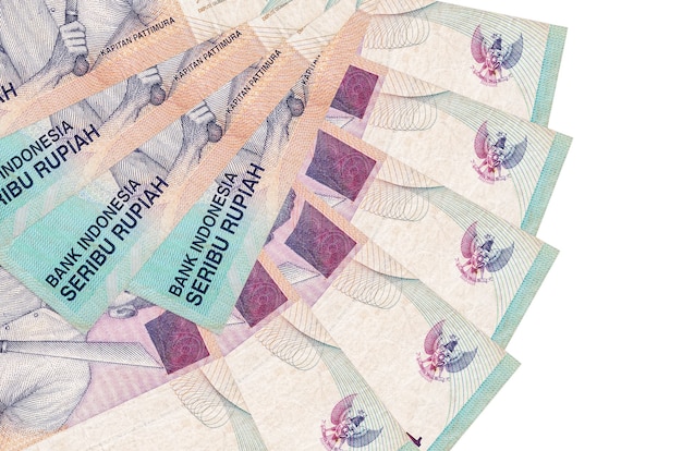 1000 banconote rupie indonesiane si trova isolato sul muro bianco con copia spazio impilato a forma di ventaglio da vicino. Concetto di transazioni finanziarie
