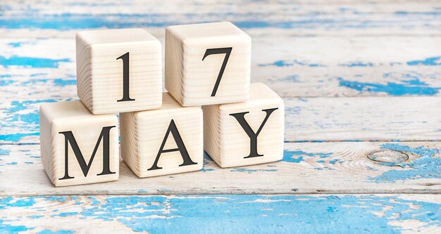 17 maggio. Cubi di legno con data del 17 maggio su sfondo di legno blu antico.