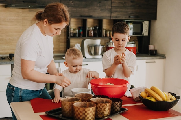 18112018 Vinnitsa Ucraina mamma con bambini impasta l'impasto per deliziosi pasticcini che preparano in cucina a casa