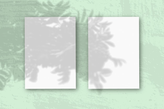 2 fogli verticali di carta bianca strutturata sul tavolo verde morbido