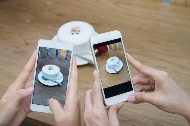 2 mani delle donne che prendono la foto del caffè dal telefono cellulare.