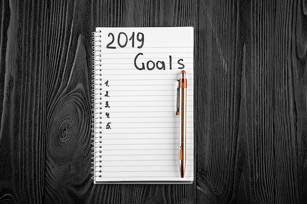 2019 GOALS sul suo taccuino. Concetto di risoluzioni del nuovo anno. Vista dall&#39;alto.
