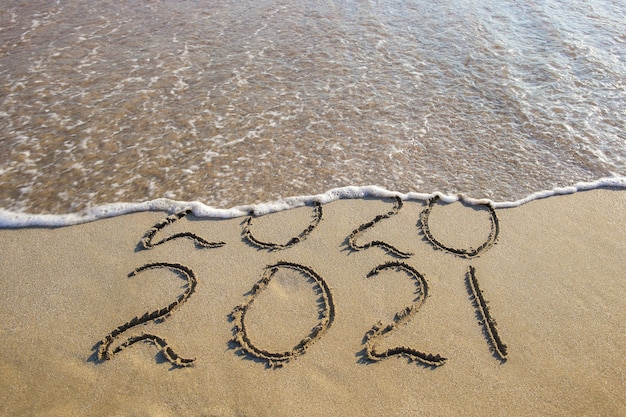 2020, 2021 anni scritti sulla spiaggia sabbiosa del mare