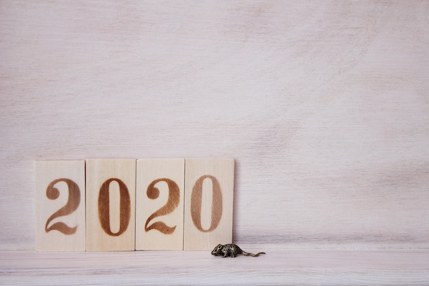 2020 con figure in legno sulla superficie in legno e un topolino di metallo