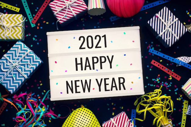 2021 felice anno nuovo e concetti di celebrazione con testo sulla scatola luminosa del cinema e puntello di festa colorato su sfondo scuro attività divertente e del festival